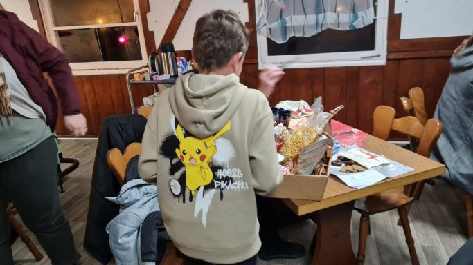 Junge mit Pikachu-Hoodie sitzt an einem Tisch in einem gemütlichen Raum.