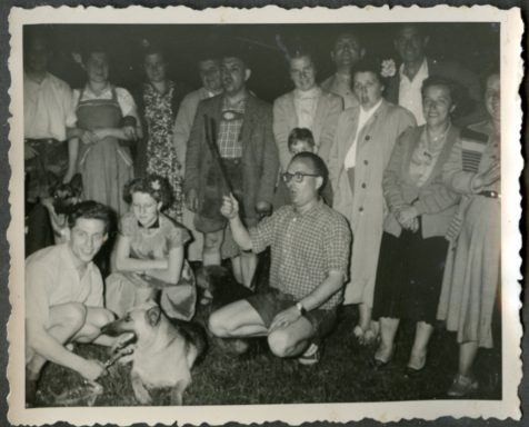 Eine Gruppe von Menschen versammelt sich um einen Hund im Freien.